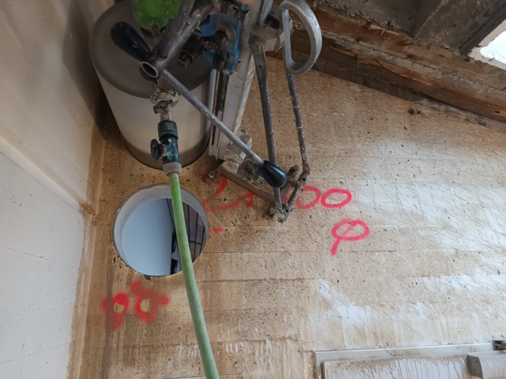 Geführte Kernbohranlage mit grosser Bohrkrone an einer Rohbauwand